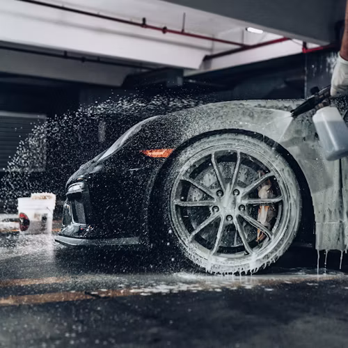 Professional automotive detailing with soap being applied to a vehicle